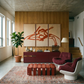 Modern living room with abstract art, red and white furniture, and a plant.