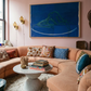 Living room with a pink wall, sectional sofa, and abstract painting.