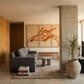 Modern living room with gray sofa, abstract art, and concrete pillar.