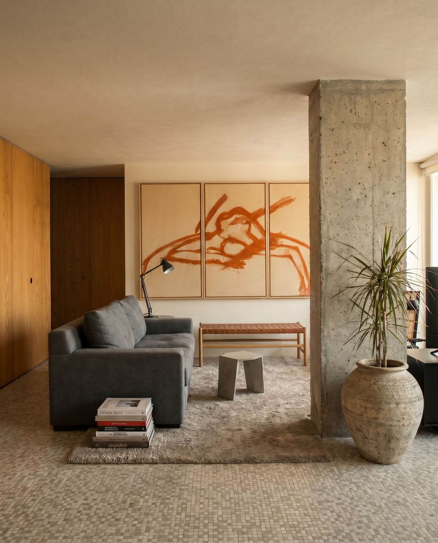 Modern living room with gray sofa, abstract art, and concrete pillar.