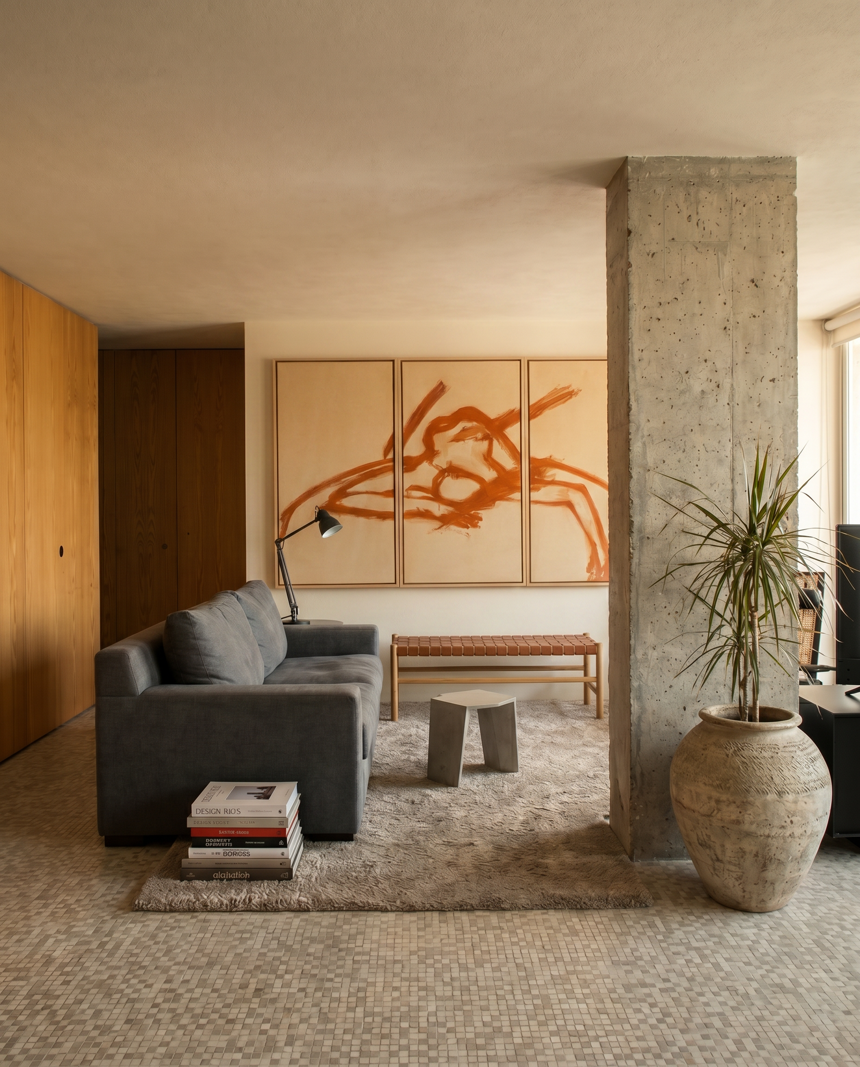 Modern living room with gray sofa, abstract art, and concrete pillar.