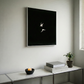 Modern interior with a black framed artwork on the wall, a console table with books and a candle. Bird 2 – Elegant Nature Canvas Print | Luxury Wall Art | Brume Art