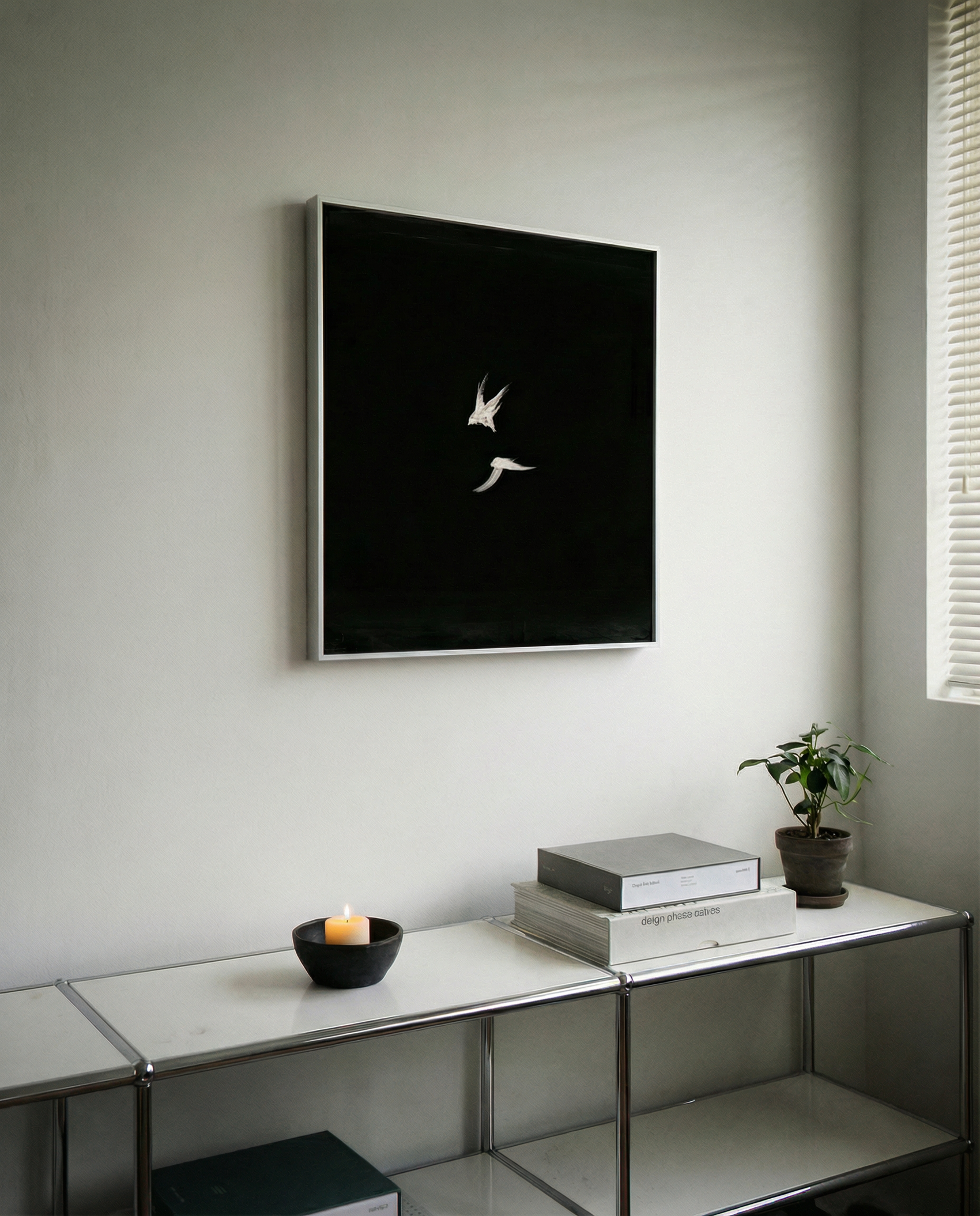 Modern interior with a black framed artwork on the wall, a console table with books and a candle. Bird 2 – Elegant Nature Canvas Print | Luxury Wall Art | Brume Art