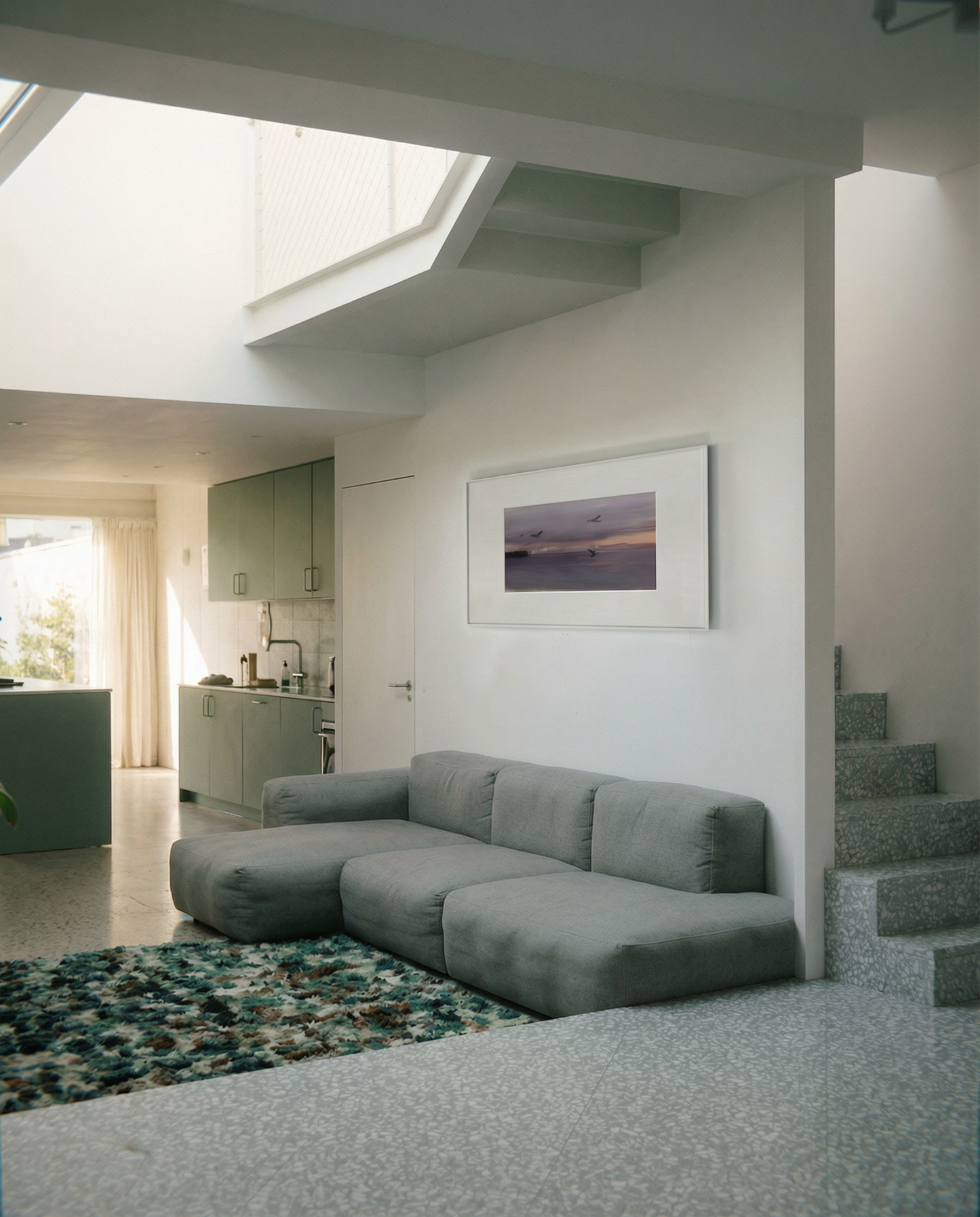 Modern living room with a gray sectional sofa, framed artwork on the wall, and a kitchen in the background. Away – Minimalist Abstract Canvas Art | Large Luxury Wall Decor | Brume Art