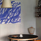 Small dining area with a round table, chairs, and abstract blue artwork on the wall. Noise 3 – Textured Abstract Canvas Art | Premium Luxury Wall Decor | Brume Art | Luxury Wall Decor | Large Canvas Wall Art | Oversized Wall Hanging-Brume art