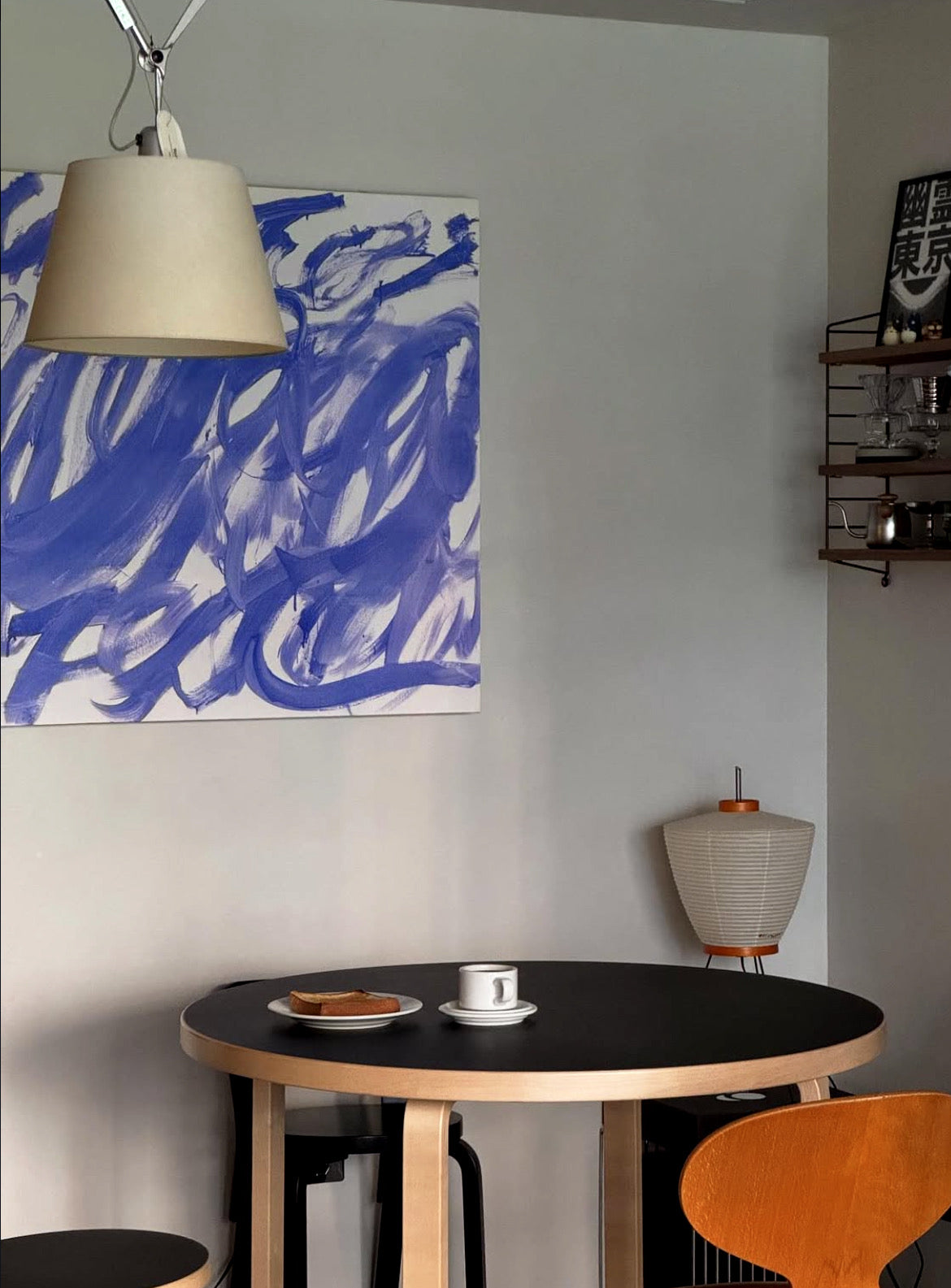 Small dining area with a round table, chairs, and abstract blue artwork on the wall. Noise 3 – Textured Abstract Canvas Art | Premium Luxury Wall Decor | Brume Art | Luxury Wall Decor | Large Canvas Wall Art | Oversized Wall Hanging-Brume art