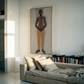 Living room with a gray sofa, books on a shelf, and a large framed portrait of a man on the wall. Fisherman of manila-Figurative Canvas Wall Art | Premium Luxury Print | Brume Art | Luxury Wall Decor | Large Canvas Wall Art | Oversized Wall Hanging-Brume art